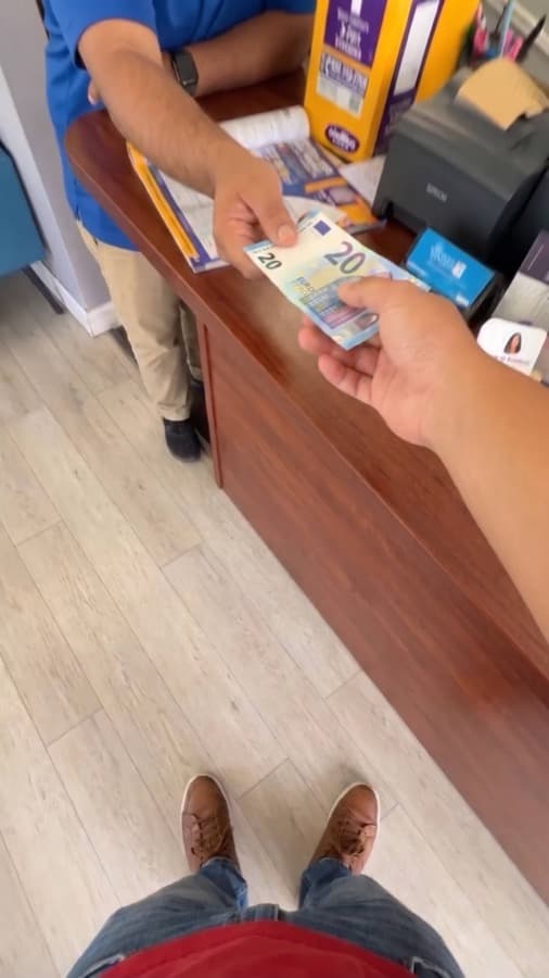 A Google review card on a shop counter, tapped with a phone (6)